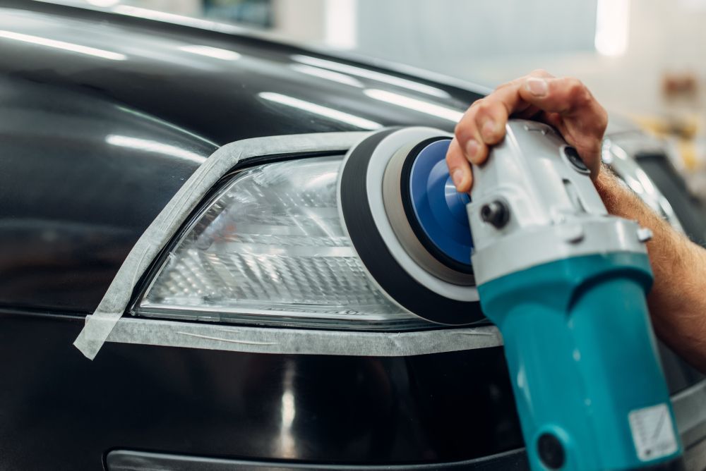Técnico realizando el pulido de faros del coche.